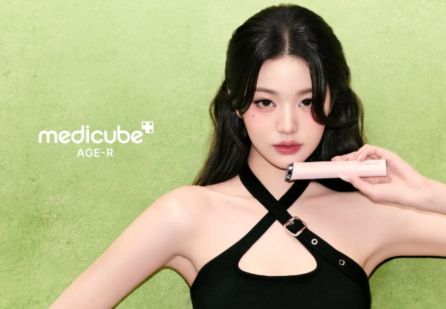IVE's Jang Wonyoung holding the Medicube AGE-R Booster Pro beauty device.
