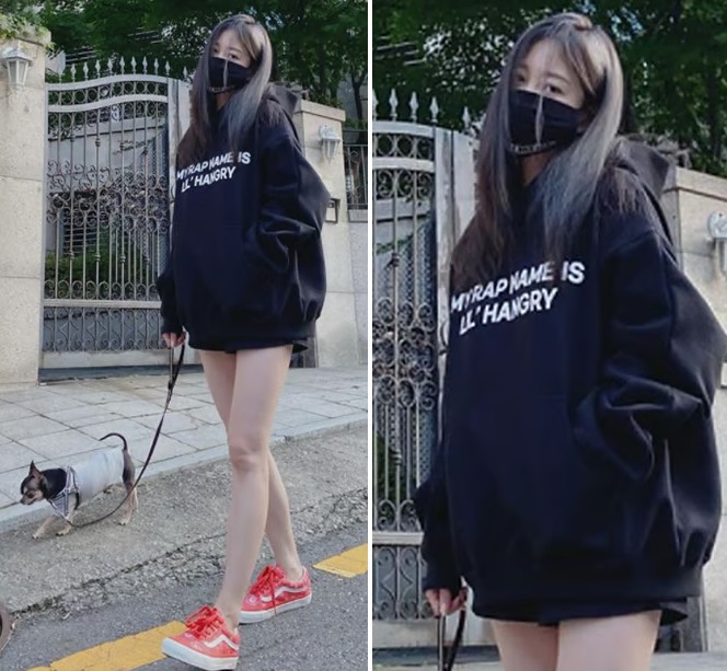 A female K-Pop idol styling an oversized hoodie with the 'bottoms-missing' look and long boots.