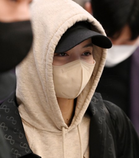 A K-Pop idol completing an oversized hoodie look with a stylish beanie.
