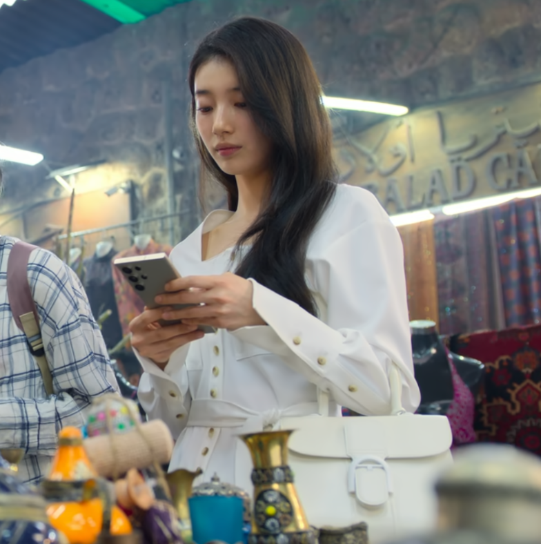 Suzy wearing a romantic, flowy blouse, a key fashion item from her look in "Everything Will Come True".