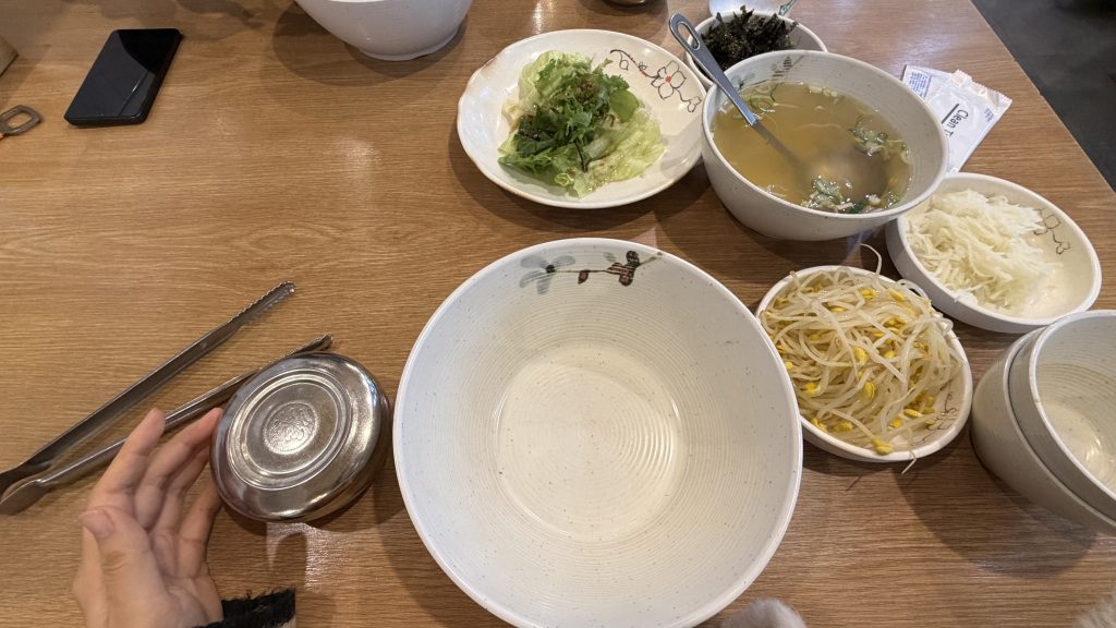 Table setting at Manboki with big bowl, seaweed, and vegetables to eat with spicy korean baby octopus